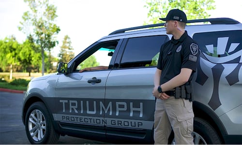 Triumph Protection Group employee stands beside a branded company vehicle